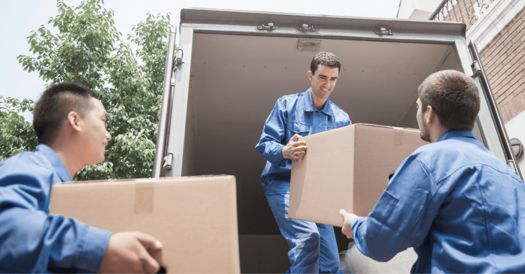Three movers working together to load boxes onto a moving truck